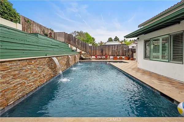 a kitchen with stainless steel appliances kitchen island granite countertop a sink a stove a dining table and chairs