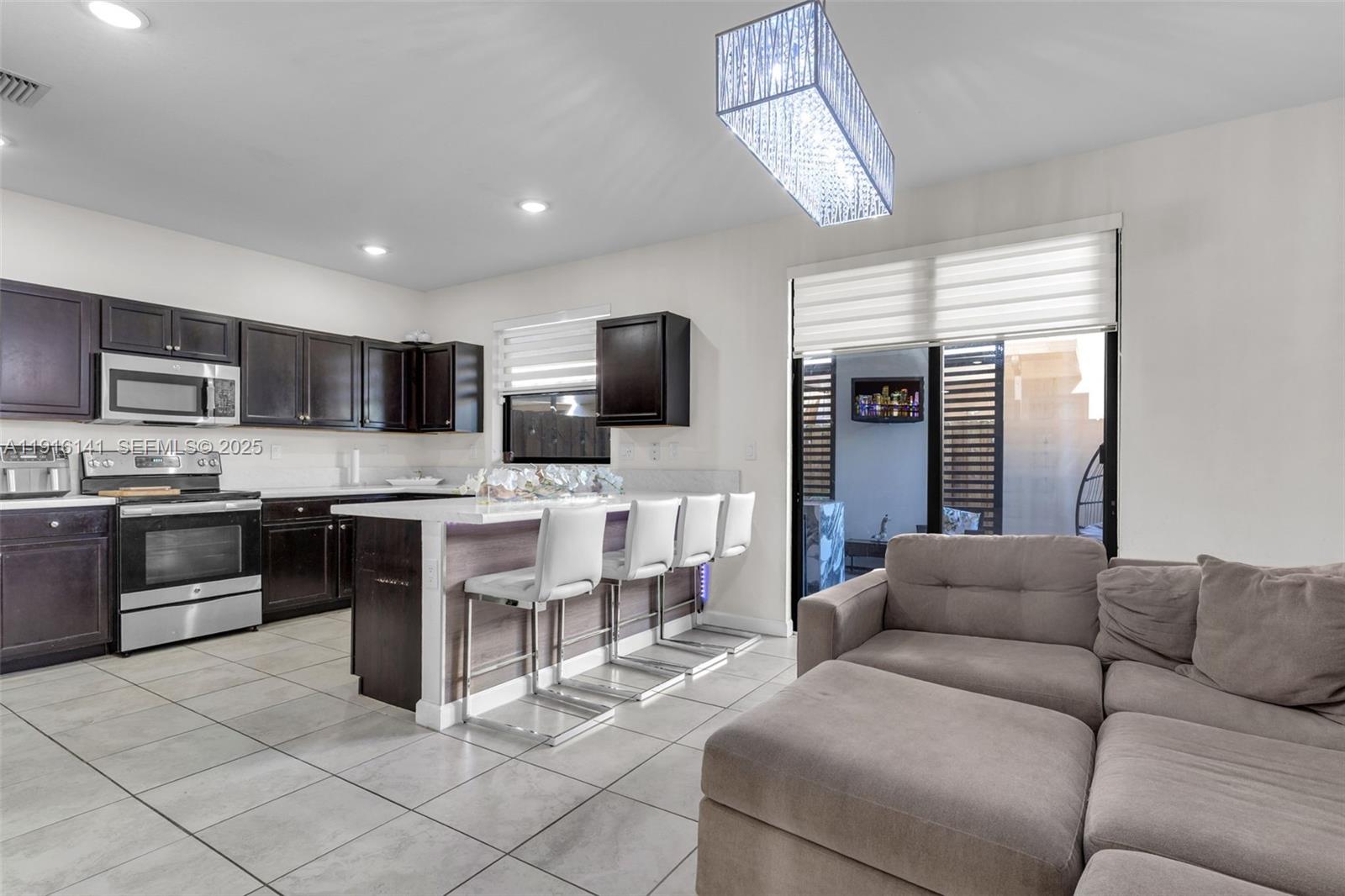 11413 Southwest 252nd Terrace Homestead, FL 33032 - Photo 11 of 40 a living room kitchen with a sink and kitchen