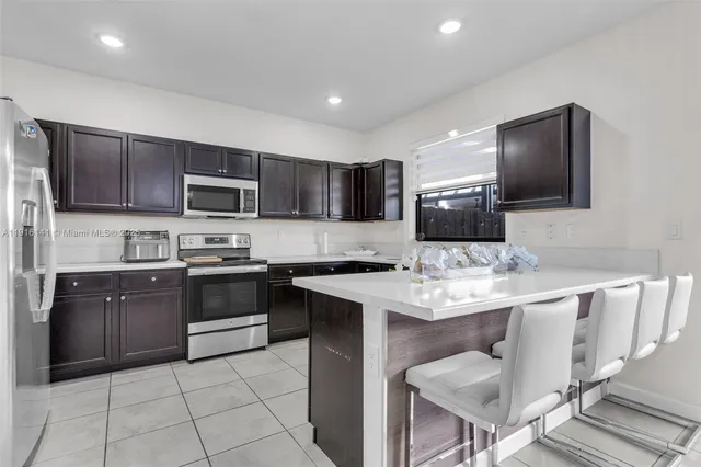 a kitchen with a sink a stove a microwave a counter top space and cabinets