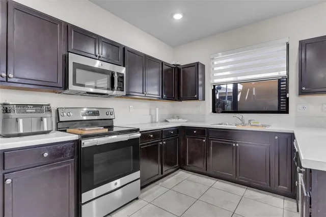 a kitchen with stainless steel appliances granite countertop a stove microwave and sink