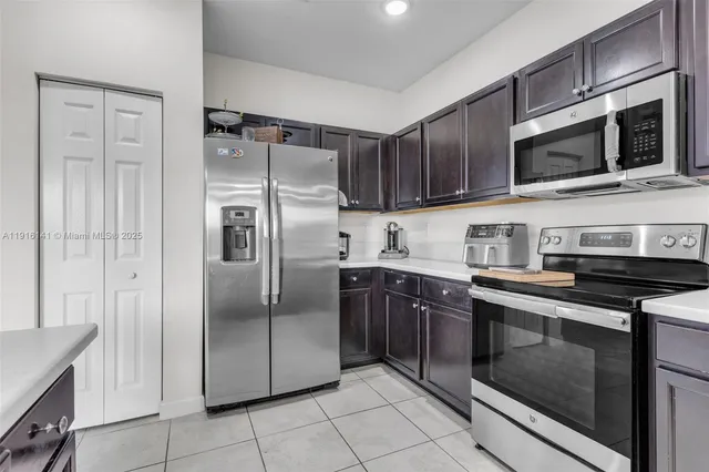 a kitchen with stainless steel appliances granite countertop a refrigerator and a stove top oven