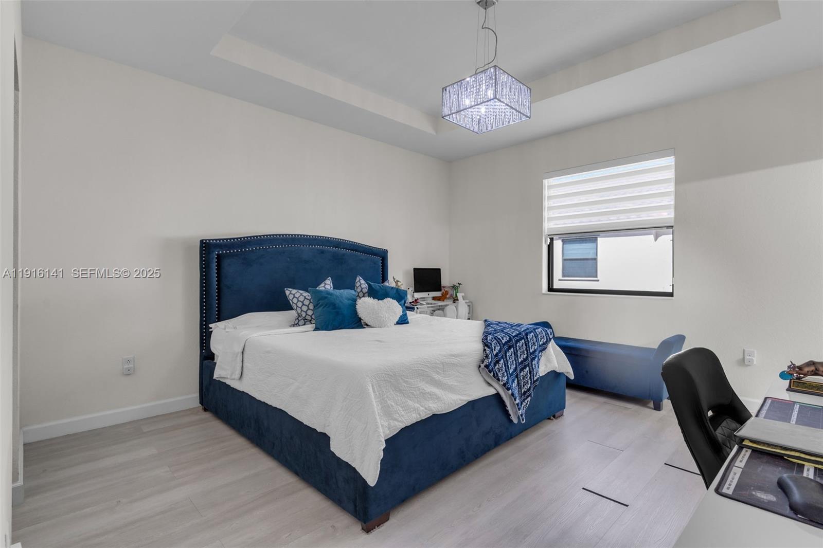 11413 Southwest 252nd Terrace Homestead, FL 33032 - Photo 18 of 40 a bedroom with a bed a chair and a chandelier