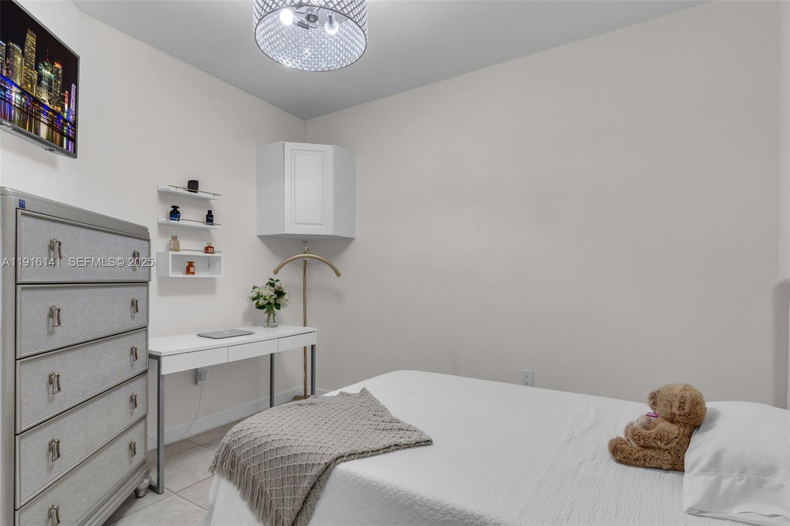 11413 Southwest 252nd Terrace Homestead, FL 33032 - Photo 19 of 40 a bedroom with a bed and a chandelier