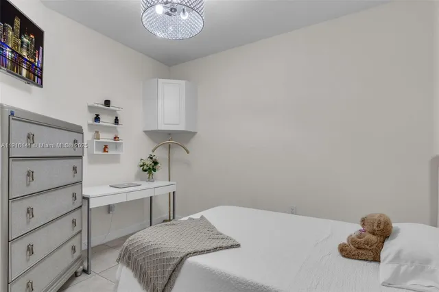 a bedroom with a bed and a chandelier