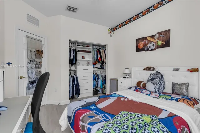 a bedroom with a bed a desk and chair