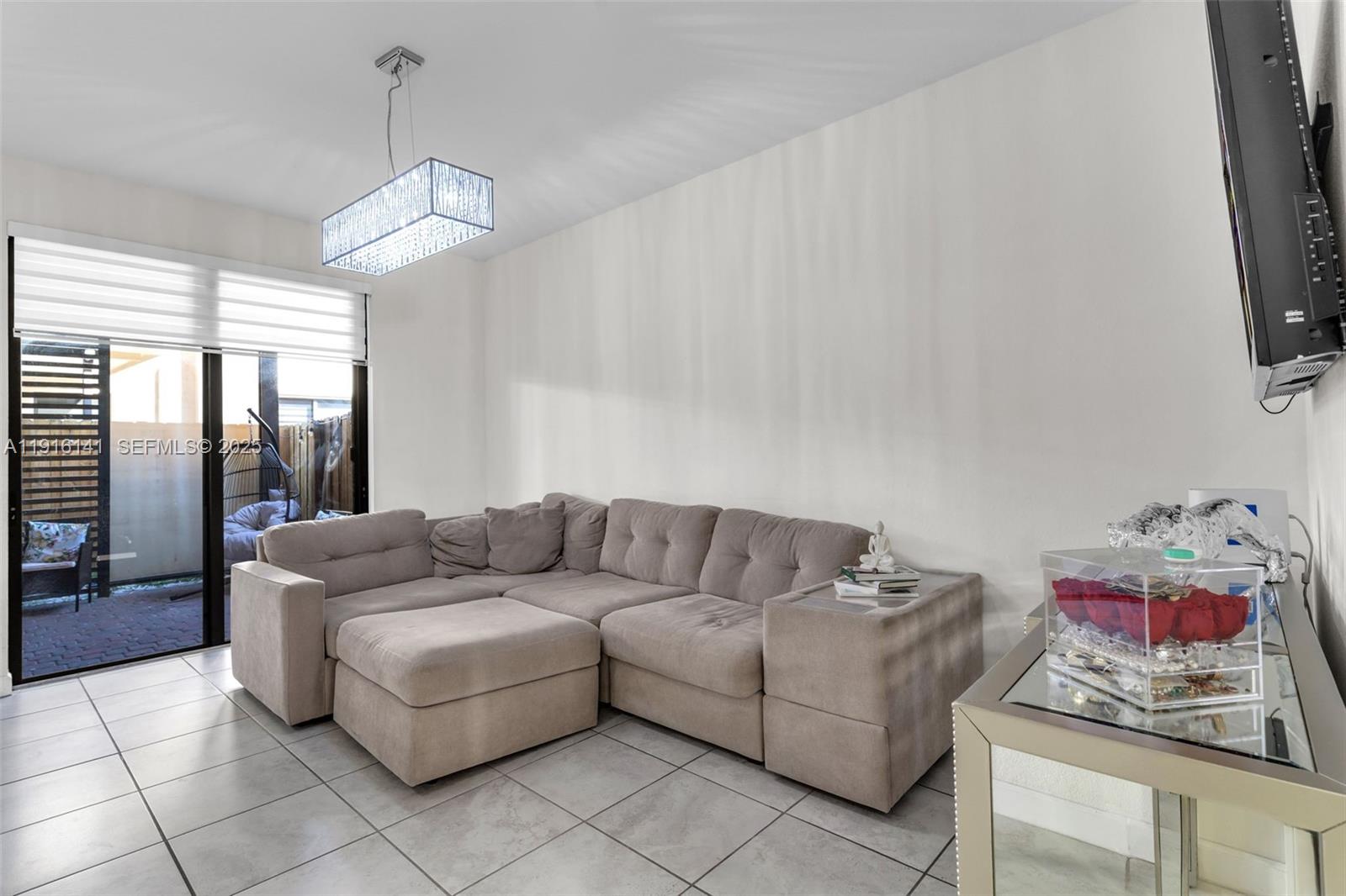 11413 Southwest 252nd Terrace Homestead, FL 33032 - Photo 5 of 40 a living room with furniture and a flat screen tv