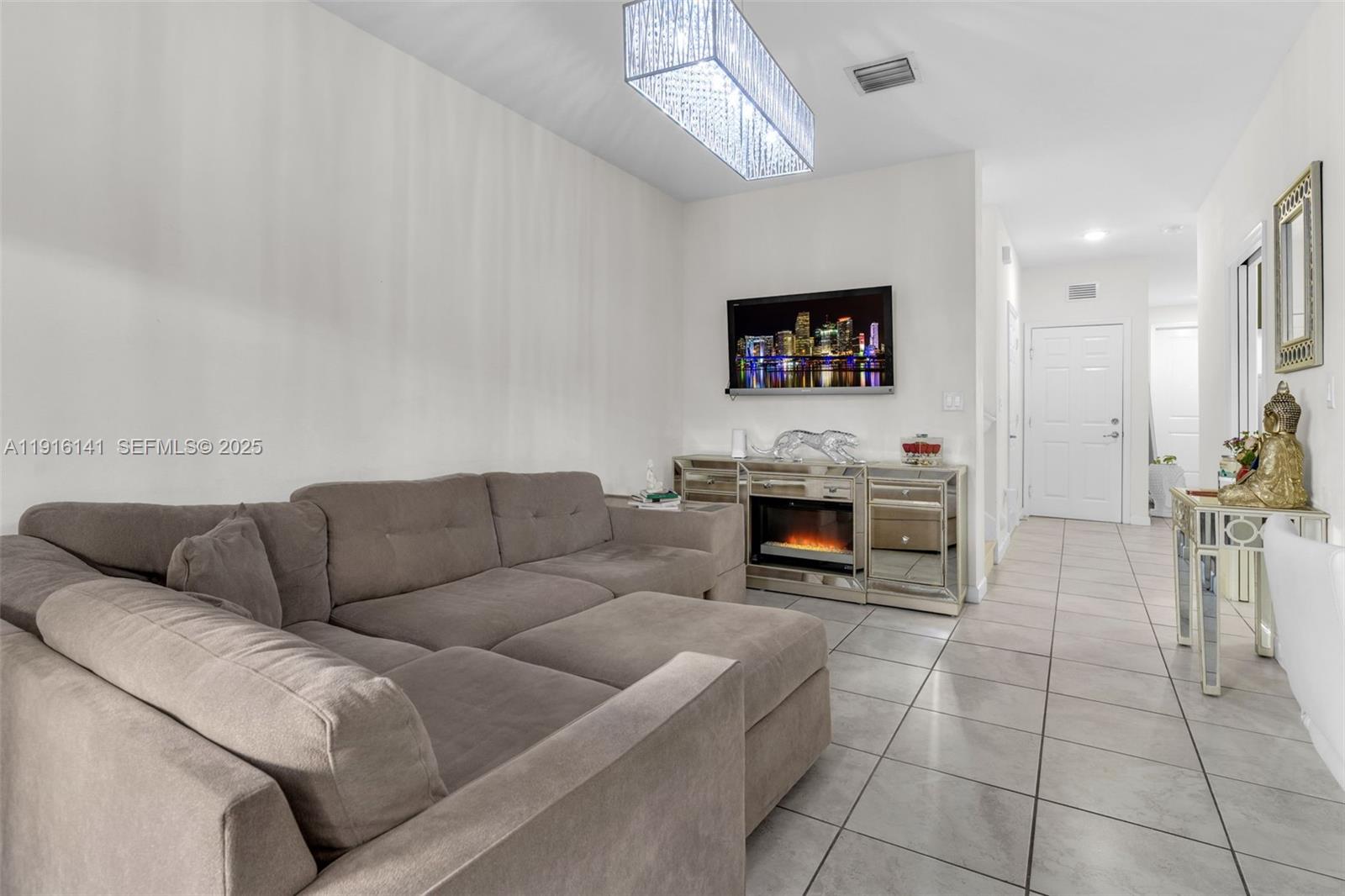 11413 Southwest 252nd Terrace Homestead, FL 33032 - Photo 6 of 40 a living room with furniture a fireplace and a flat screen tv