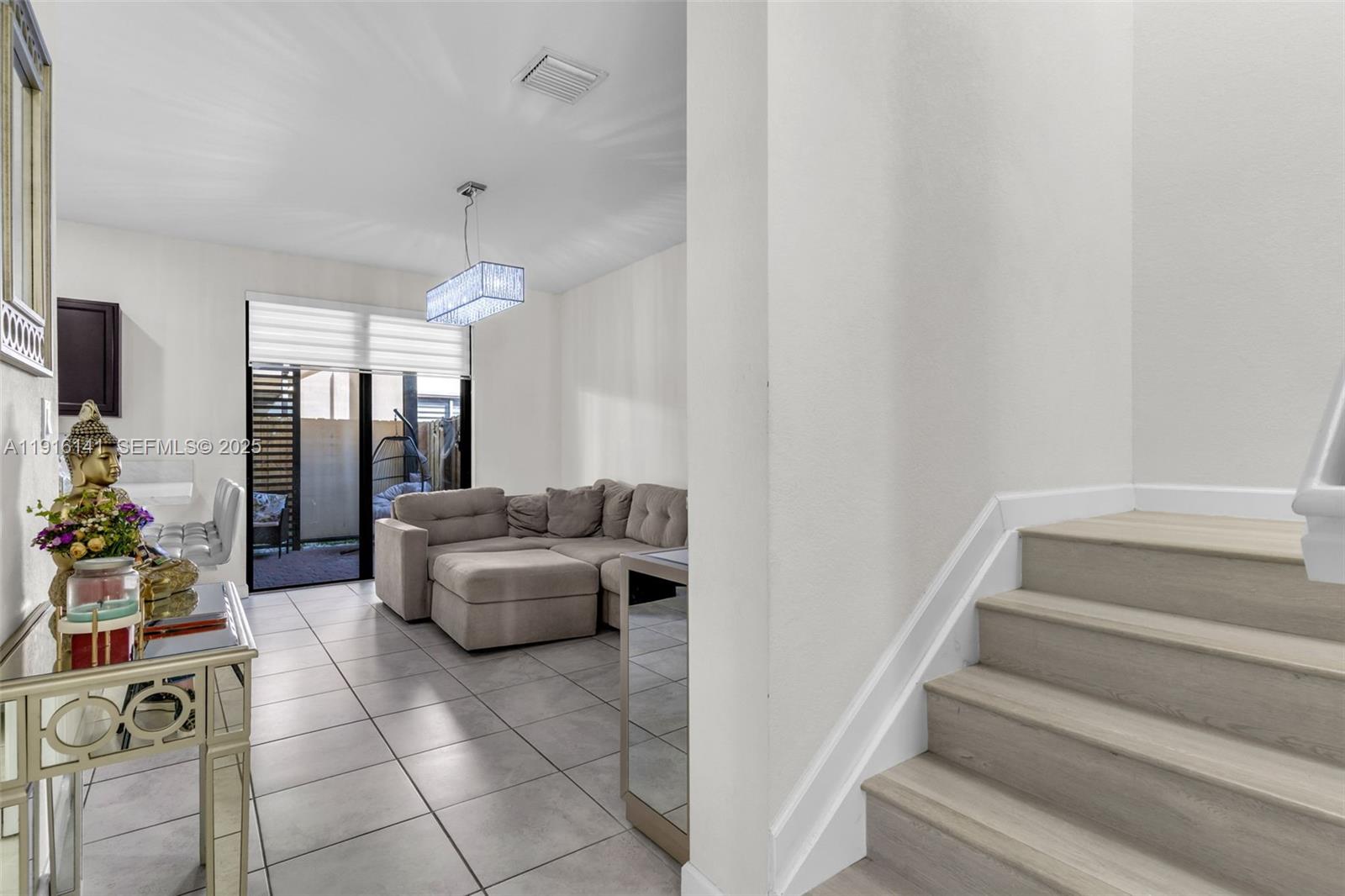 11413 Southwest 252nd Terrace Homestead, FL 33032 - Photo 7 of 40 a living room with furniture and a chandelier