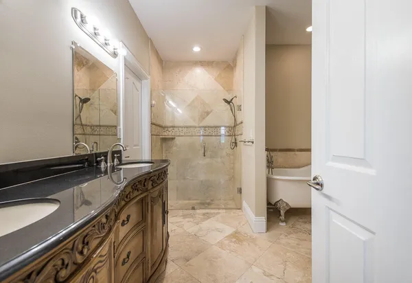 a bathroom with a granite countertop sink a toilet and a shower