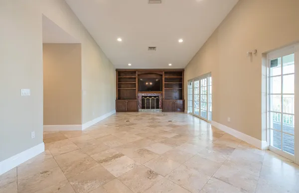 a view of an empty room with a window and fireplace