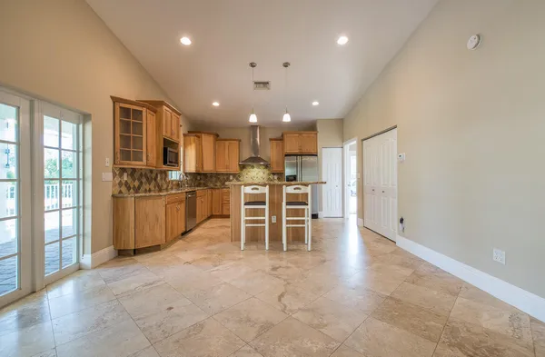 a large white kitchen with lots of counter space cabinets and appliances