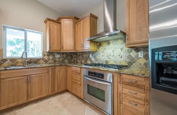 a kitchen with granite countertop a stove sink and cabinets