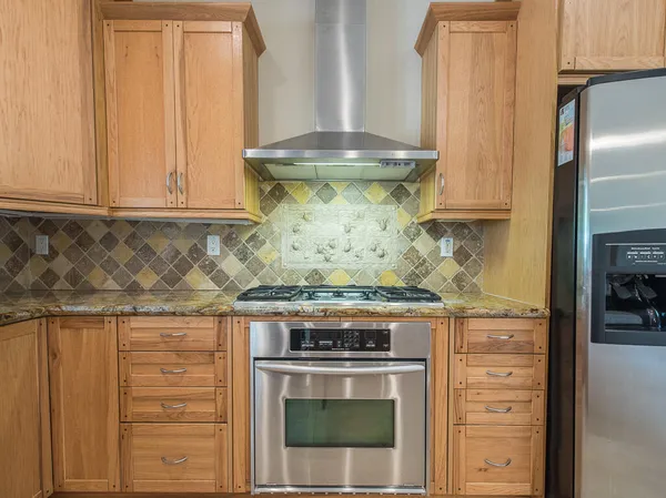 a stove top oven sitting inside of a kitchen