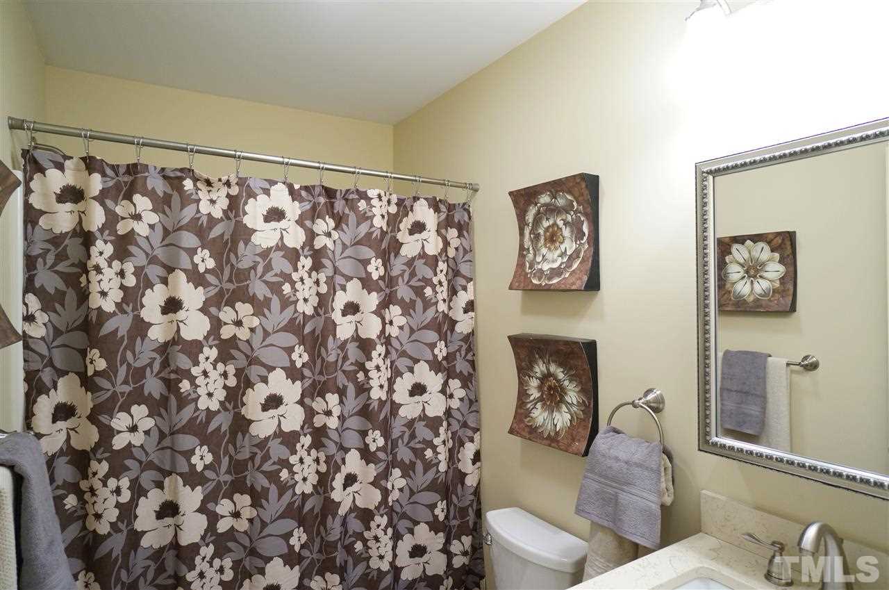3413 Gemini Drive Raleigh, NC 27604 - Photo 13 of 16 a hallway with a couch and a vase with paintings on the wall
