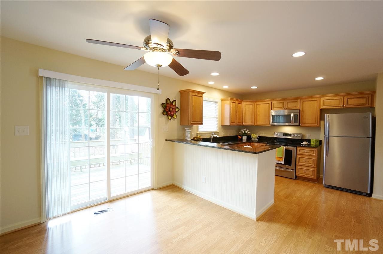 3413 Gemini Drive Raleigh, NC 27604 - Photo 4 of 16 a kitchen with stainless steel appliances kitchen island granite countertop a refrigerator a sink a stove and white cabinets