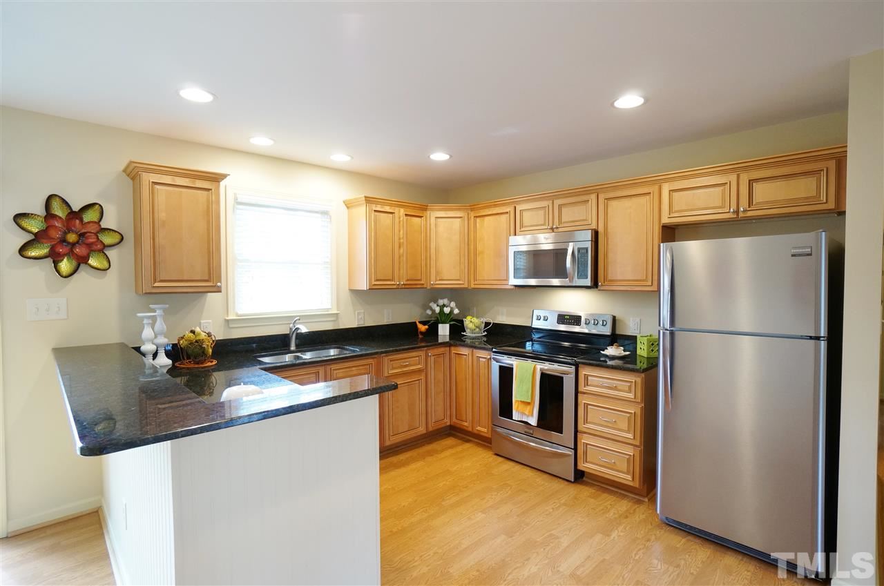 3413 Gemini Drive Raleigh, NC 27604 - Photo 5 of 16 a kitchen with stainless steel appliances granite countertop a refrigerator a sink a stove a microwave a counter space and cabinets