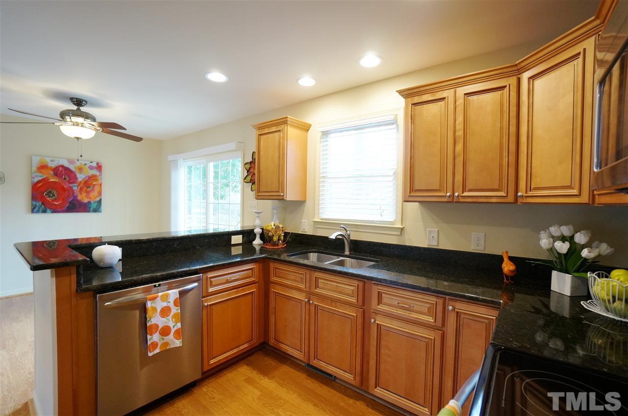 3413 Gemini Drive Raleigh, NC 27604 - Photo 7 of 16 a kitchen with granite countertop a sink a window stainless steel appliances and cabinets