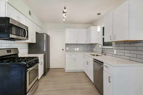 a kitchen with stainless steel appliances a sink stove and microwave