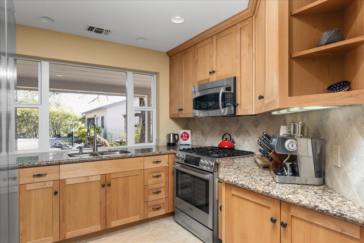 15666 Wolf Mountain Road Grass Valley, CA 95949 - Photo 18 of 78 a kitchen with stainless steel appliances granite countertop white cabinets sink and a granite counter top