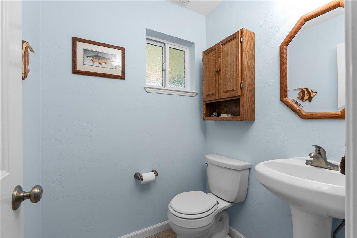 15666 Wolf Mountain Road Grass Valley, CA 95949 - Photo 22 of 78 a bathroom with a toilet a sink and mirror