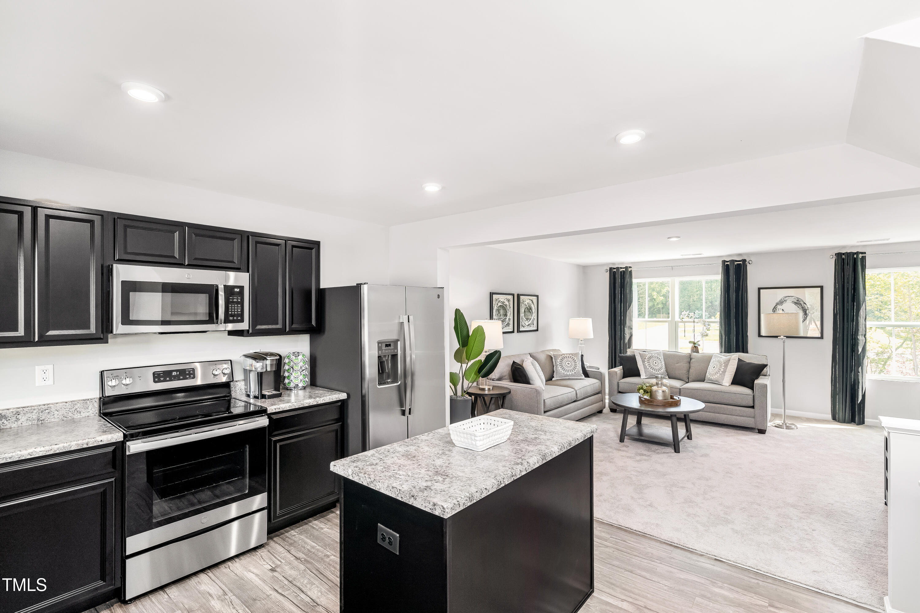 304 Grand Silo Road Raleigh, NC 27603 - Photo 3 of 15 a living room with stainless steel appliances kitchen island granite countertop a stove top oven a sink dishwasher a dining table and chairs with wooden floor