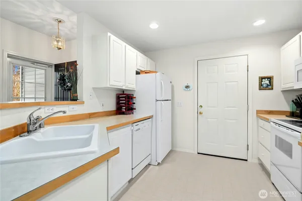 a kitchen with stainless steel appliances granite countertop a refrigerator and a sink