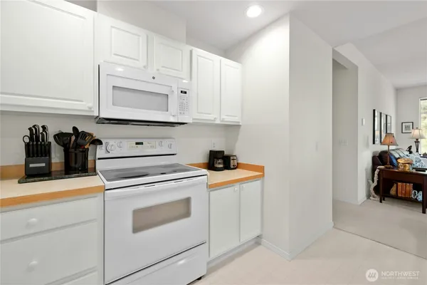 a kitchen with white cabinets and appliances