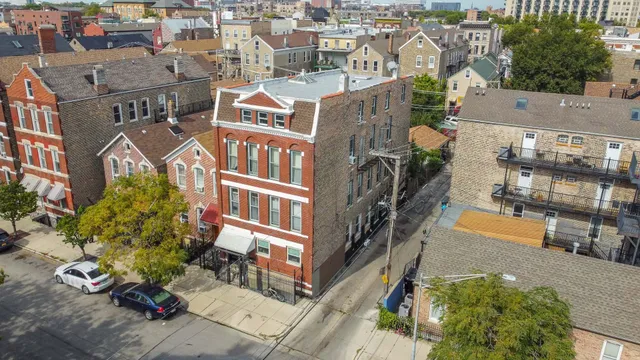 a front view of a building with lot of cars and trees