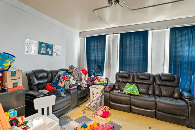 a bed room with a bed a couch and a flat screen tv