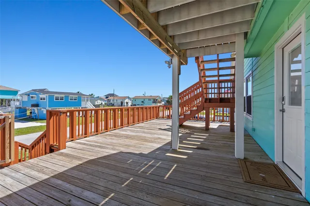 a view of a house with wooden deck and furniture