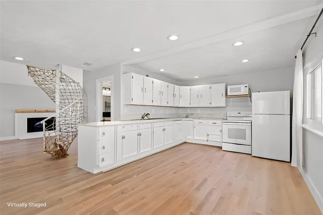 a kitchen with cabinets wooden floor and a fireplace