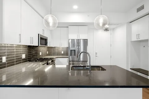 a kitchen with a sink cabinets and chandelier