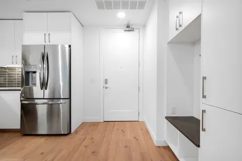 a kitchen with stainless steel appliances a refrigerator and a hard wood floor