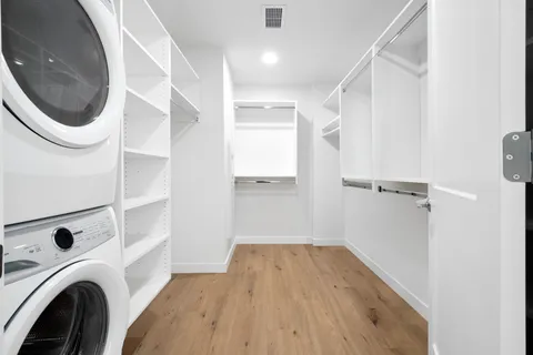 a view of walk in closet with clothes and shoes
