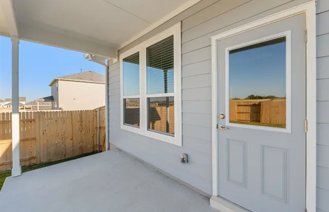 a view of backyard with barbeque grill and wooden fence