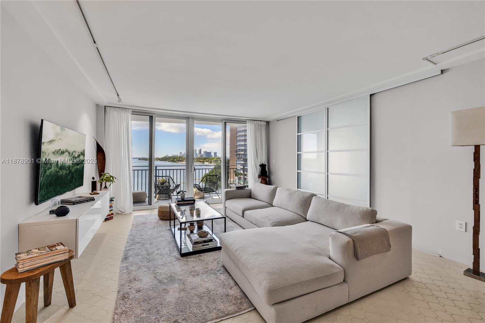 770 Northeast 69th Street, Unit 6H Miami, FL 33138 - Photo 67 of 71 a living room with furniture large window and flat screen tv