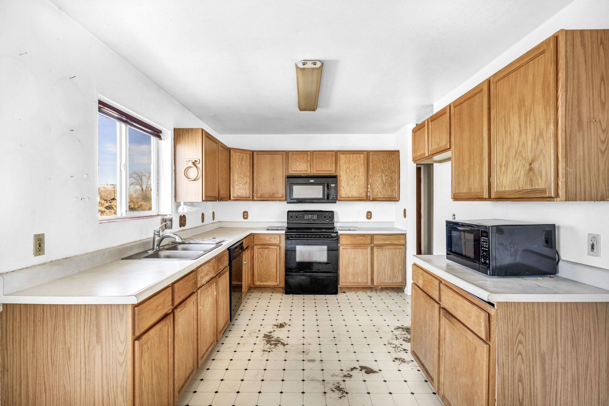 446-460 Lake View Drive Herlong, CA 96113 - Photo 4 of 13 a kitchen with stainless steel appliances a stove a sink dishwasher a refrigerator and white cabinets with wooden floor