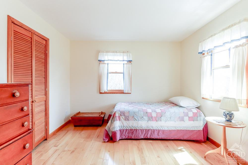 286 West Hill Road New Lebanon, NY 12125 - Photo 19 of 36 a bedroom with a bed and wooden floor