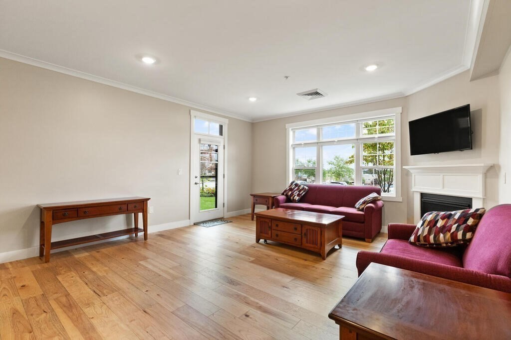 11 Executive Drive, Unit 118 Stoneham, MA 02180 - Photo 11 of 36 a living room with furniture a flat screen tv and a fireplace