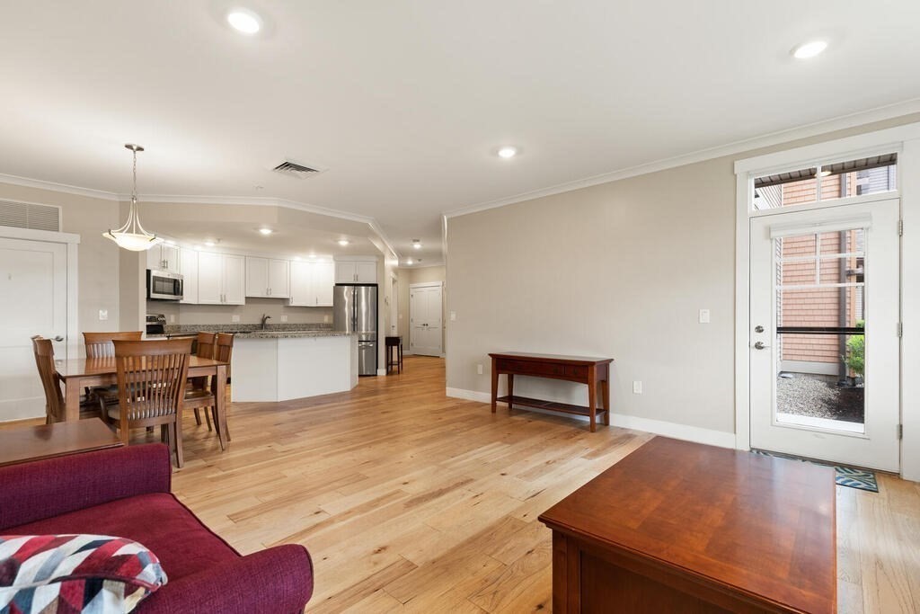 11 Executive Drive, Unit 118 Stoneham, MA 02180 - Photo 12 of 36 a living room with furniture and a dining table with kitchen view