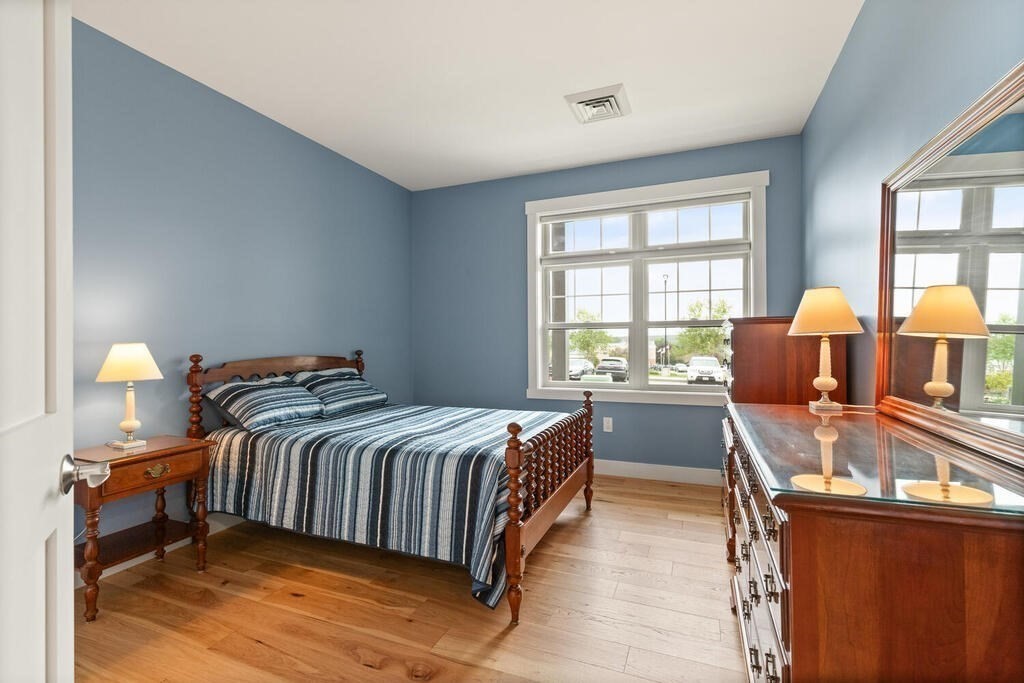 11 Executive Drive, Unit 118 Stoneham, MA 02180 - Photo 22 of 36 a bedroom with a bed and wooden floor