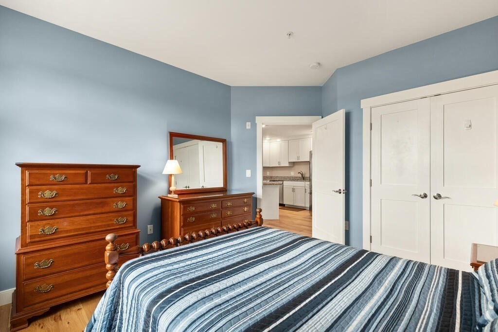 11 Executive Drive, Unit 118 Stoneham, MA 02180 - Photo 24 of 36 a bedroom with a bed and wooden floor