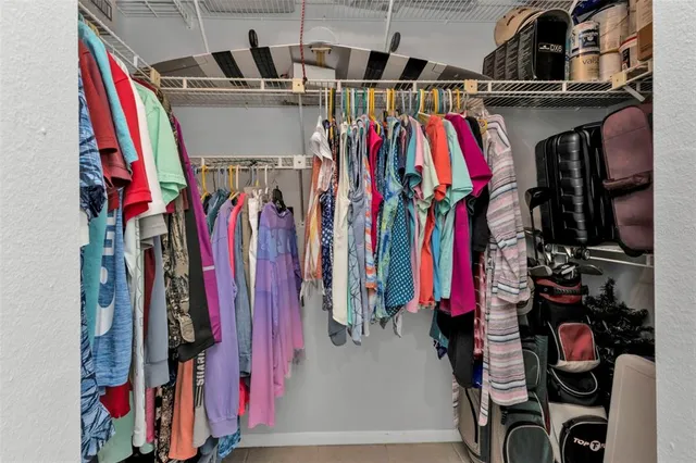 a view of walk in closet with clothes and shoes