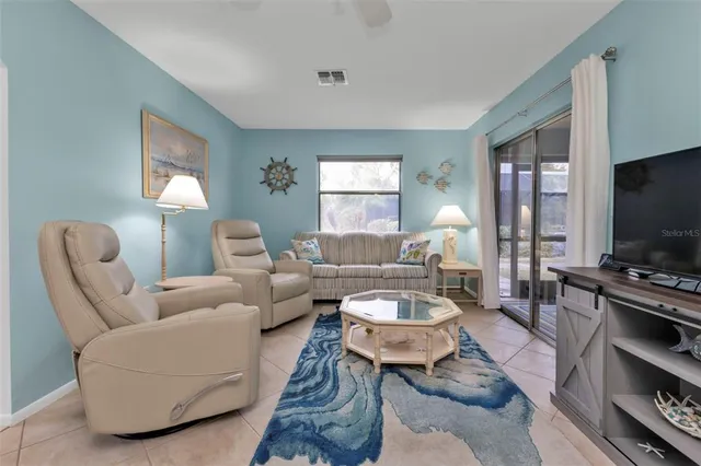 a living room with furniture a flat screen tv and a window