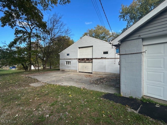 7987 Ridge Road North Royalton, OH 44133 - Photo 5 of 45 View of side of home featuring an outdoor structure, concrete block siding, and a lawn