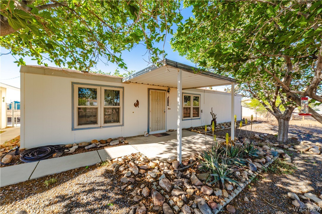 3176 West Malibu Road Golden Valley, AZ 86413 - Photo 1 of 62 This well-kept property features a covered front porch, a concrete walkway, and a landscaped area with rocks and desert plants