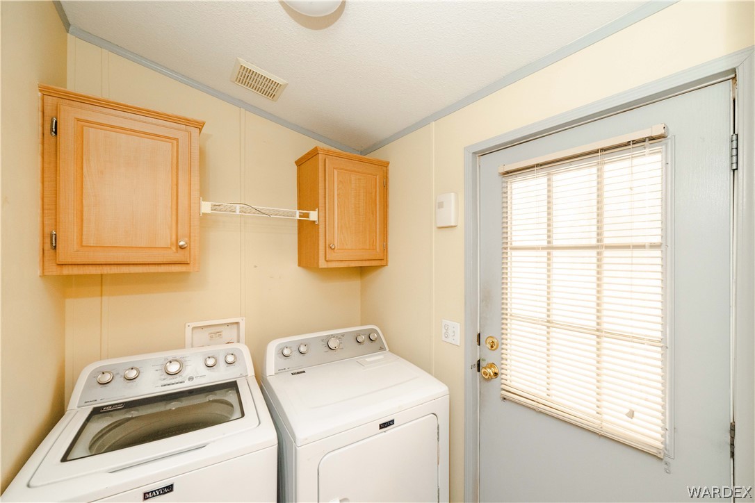 3176 West Malibu Road Golden Valley, AZ 86413 - Photo 11 of 62 The utility area features a full-size washer and dryer, wall-mounted cabinetry, and a door to the backyard