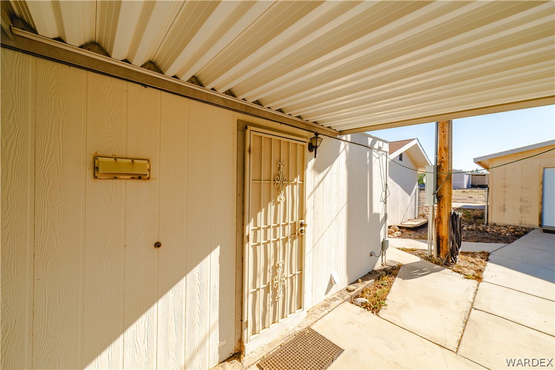 3176 West Malibu Road Golden Valley, AZ 86413 - Photo 47 of 62 The property features a covered patio area with concrete paving and a security screen door