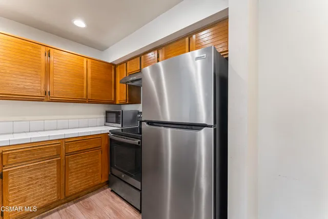 a kitchen with stainless steel appliances granite countertop a refrigerator and a sink
