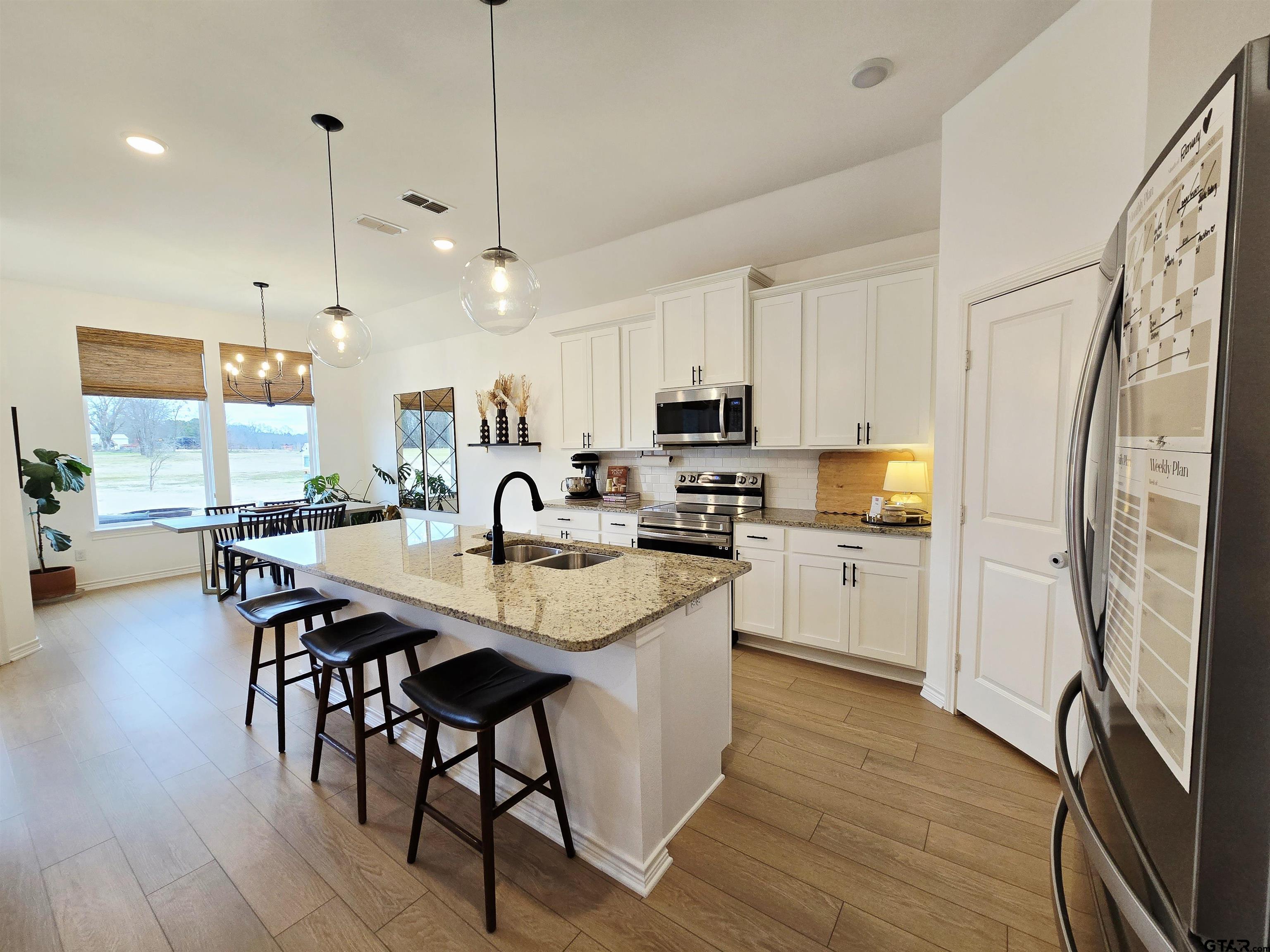 14932 Turtle Crk Rnch Road Flint, TX 75762 - Photo 18 of 33 a kitchen with stainless steel appliances granite countertop a sink a stove a refrigerator and island with wooden floor